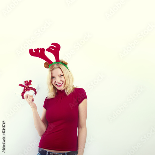 beautiful blonde woman with reindeer antlers is smiling
