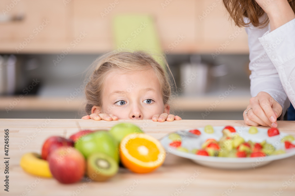 mädchen schaut neugierig auf obstsalat mädchen schaut neugierig auf obstsalat