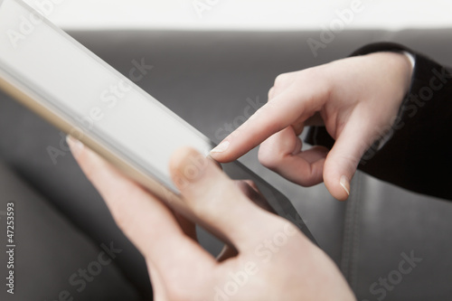 Weiblicher Zeigefinger berührt Display eines Tablet PC´s