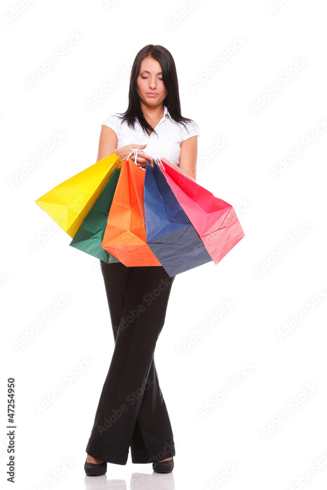 Portrait of young woman carrying shopping bags against white bac Portrait of young woman carrying shopping bags against white bac