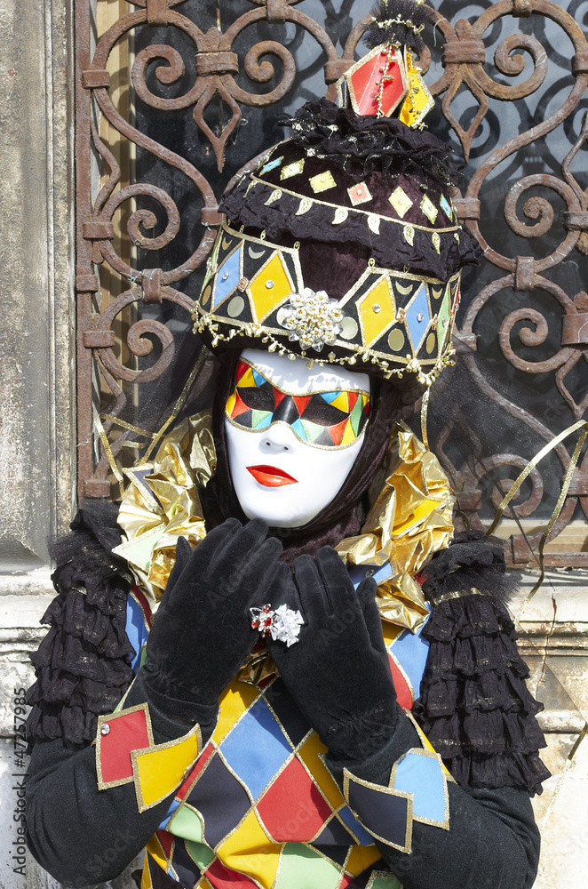 Person in Venetian costume attends the Carnival of Venice.