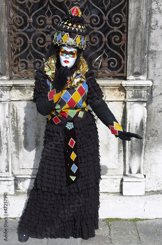 Person in Venetian costume attends the Carnival of Venice.