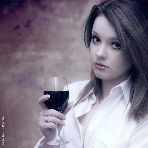 beautiful girl in white shirt with red wine grunge background