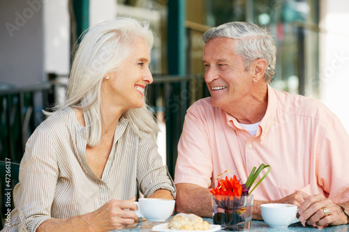 Senior Couple Enjoying Snack At Outdoor Café