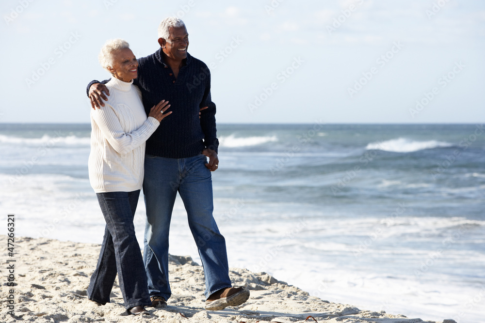 Senior Couple Walking Along Beach Together Senior Couple Walking Along Beach Together