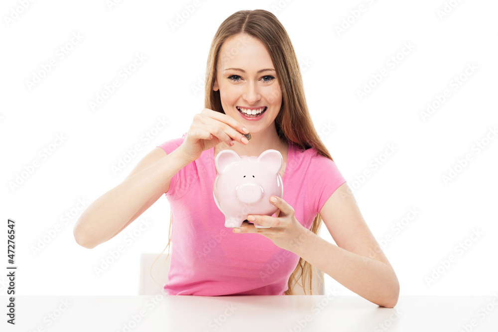 Young woman putting money in piggy bank Young woman putting money in piggy bank