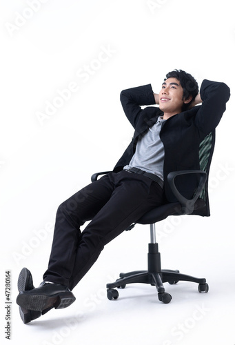 Relaxed young business man sitting on the chair