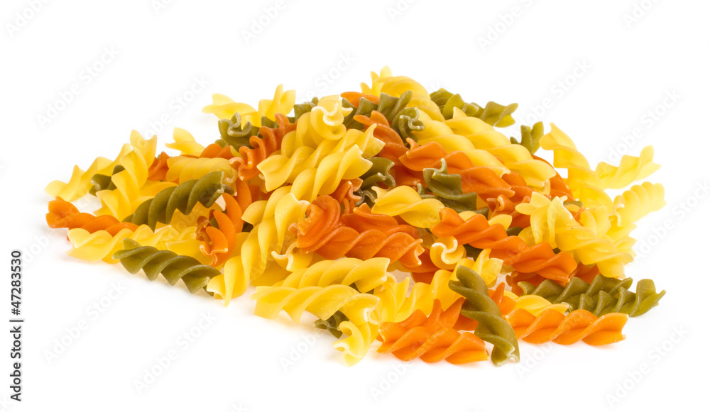 Uncooked pasta fusilli in different colours, white background Uncooked pasta fusilli in different colours, white background