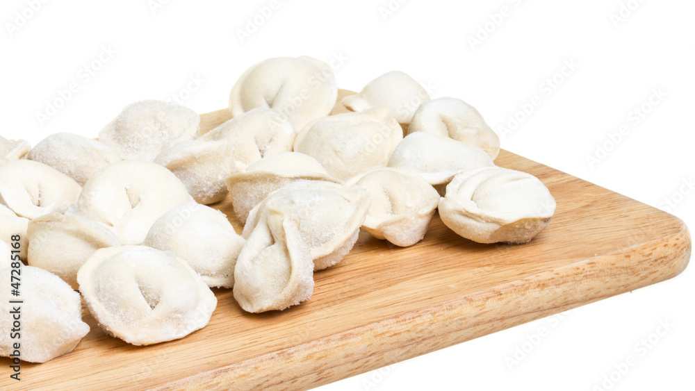 Some raw dumplings on the wooden board Some raw dumplings on the wooden board