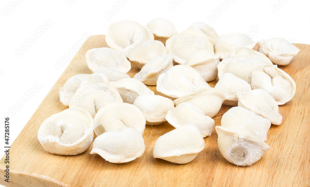 Some raw dumplings on the wooden board Some raw dumplings on the wooden board