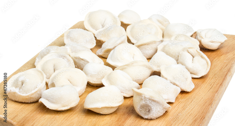 Some raw dumplings on the wooden board Some raw dumplings on the wooden board