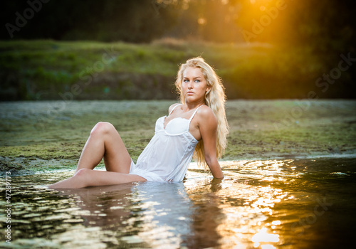 Fototapeta Naklejka Na Ścianę i Meble -  Sexy blonde woman play in lingerie in a river water
