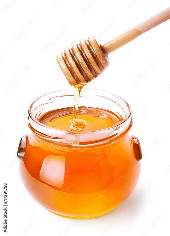 Glass jar of honey with wooden drizzler isolated on white Glass jar of honey with wooden drizzler isolated on white