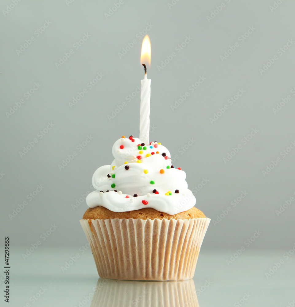 tasty birthday cupcake with candle, on grey background