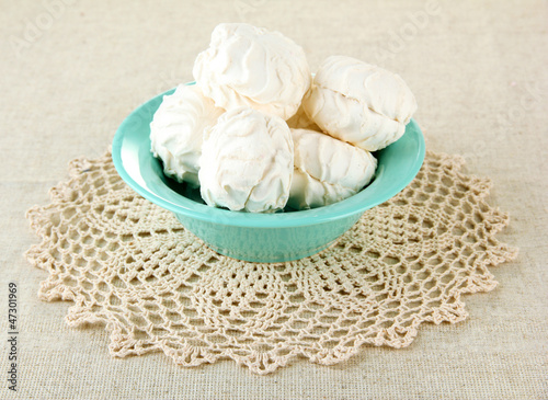 Marshmallows on color plate on light background photo