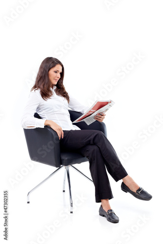 Casual 20s women reading newspaper, focused