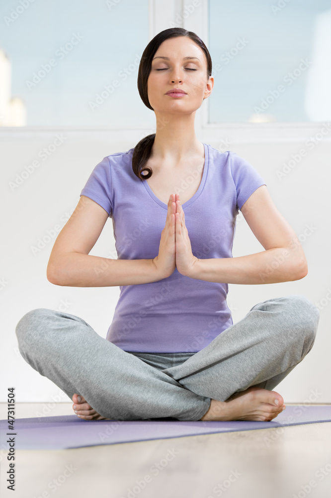 Portrait of beautiful young woman doing yoga exercise - Meditati