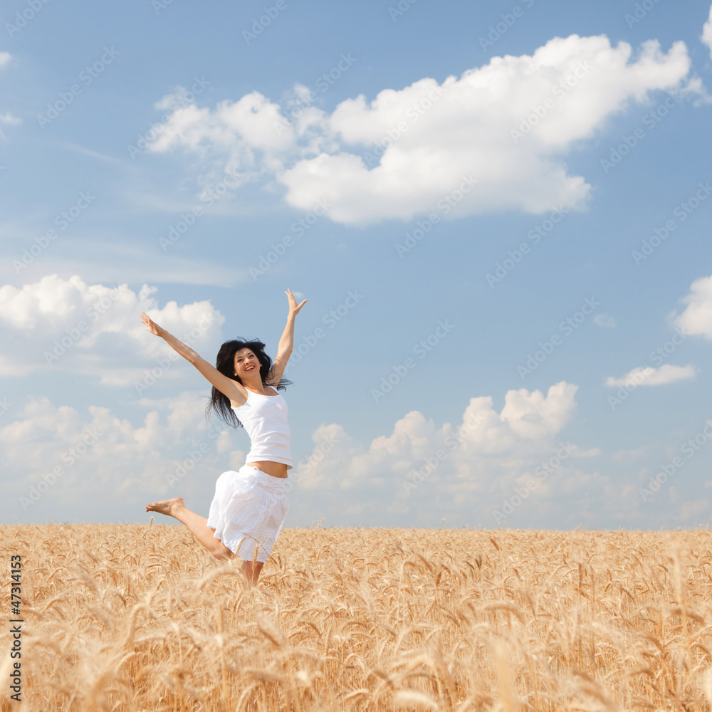 Happy woman jumping in golden wheat Happy woman jumping in golden wheat