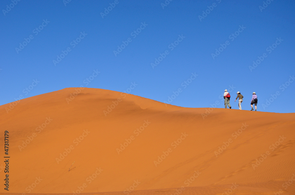 People walking on dune of Namib desert, hiking in South Africa