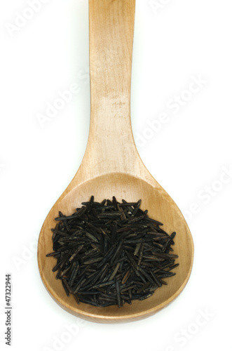 Wild black rice in wooden spoon