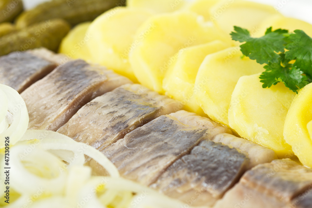 Portion of herring fish fillets with potato and onion Portion of herring fish fillets with potato and onion