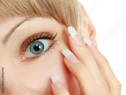 Face of girl applying cosmetic cream on skin around eyes