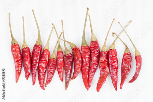 row of red peppers on white background