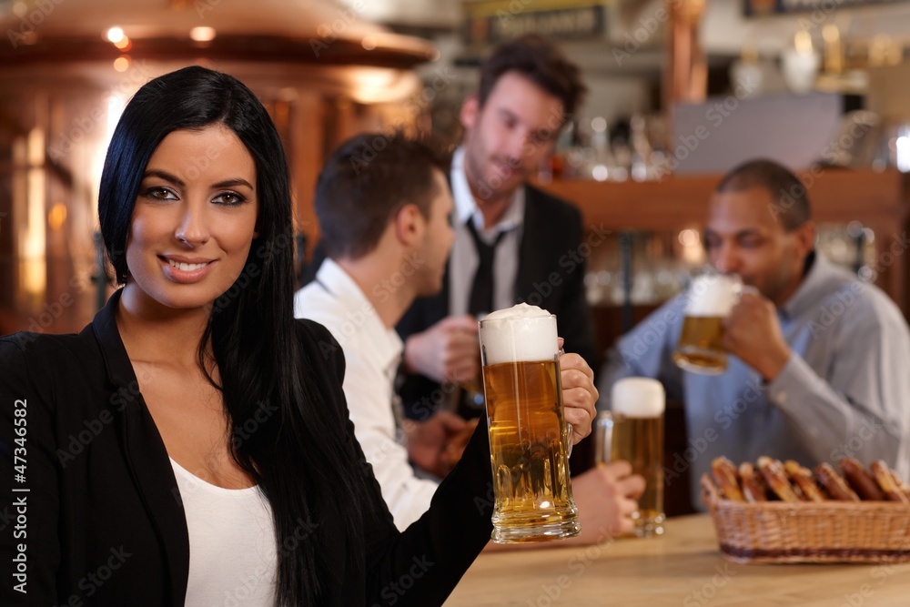 Young woman in pub with mug of beer Young woman in pub with mug of beer