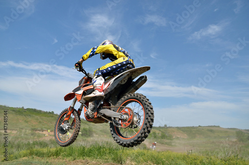 Fototapeta Naklejka Na Ścianę i Meble -  Driver motorcycle MX flies over hill