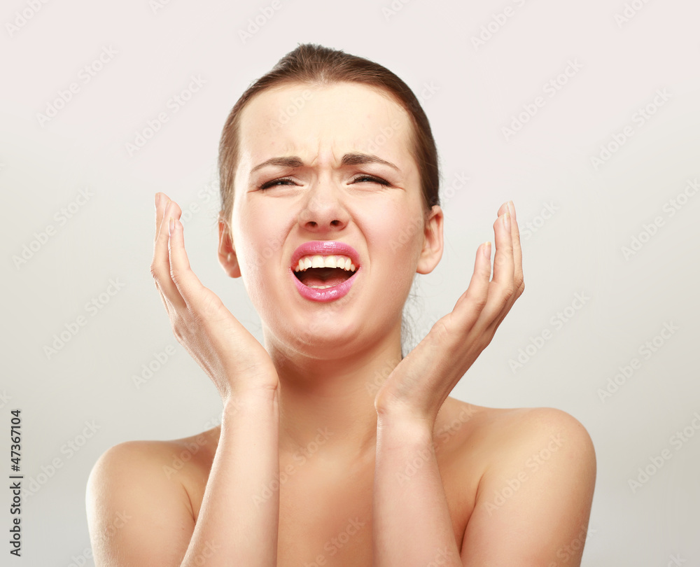 portrait of young beautiful woman having a headache against portrait of young beautiful woman having a headache against
