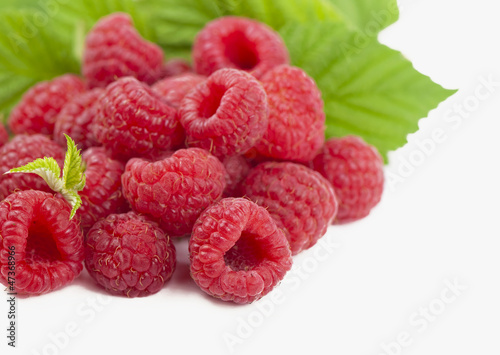raspberry with green leaf isolated on white