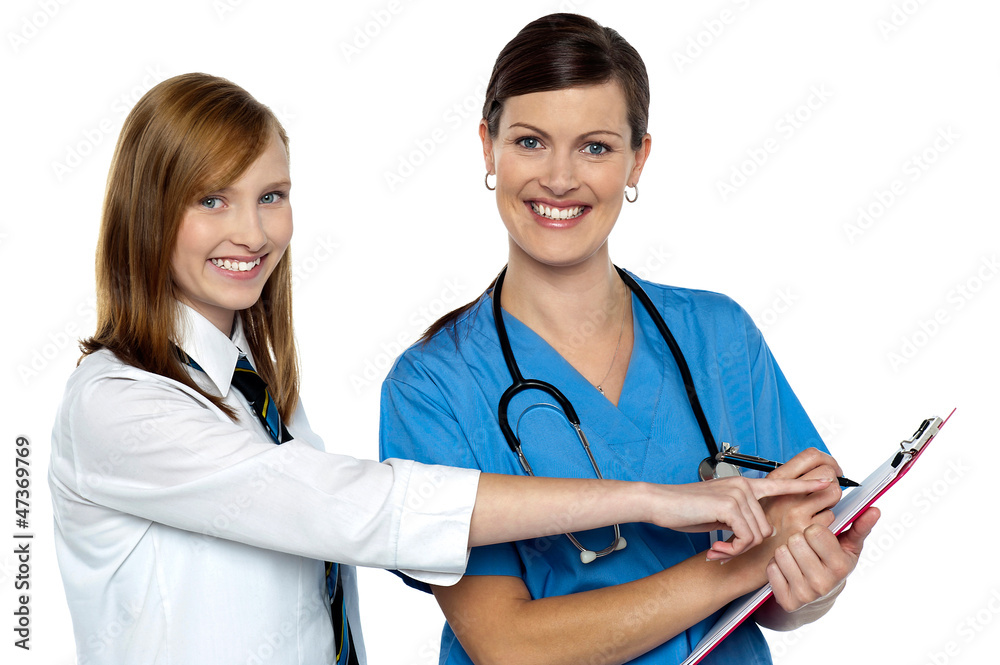 Attractive girl pointing at the doctors case sheet Attractive girl pointing at the doctors case sheet
