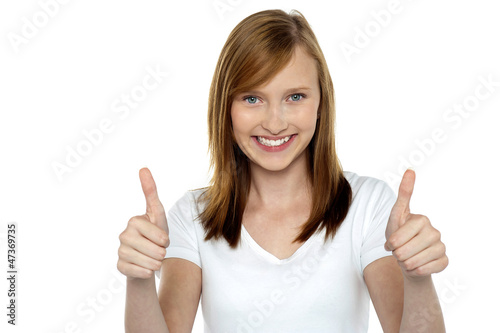 Pretty teenager gesturing double thumbs up
