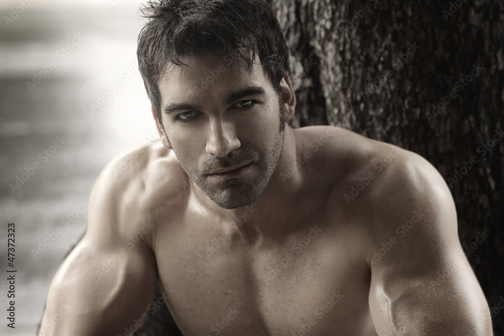 Sexy masculine man shirtless outdoors against tree Sexy masculine man shirtless outdoors against tree