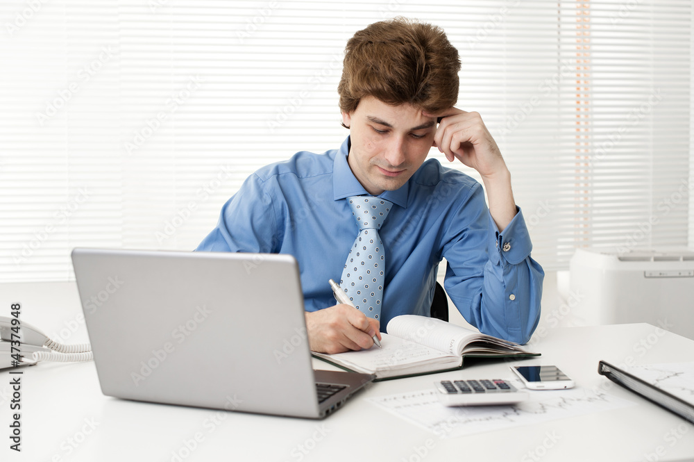 manager sitting at desk in the office, working on laptop manager sitting at desk in the office, working on laptop