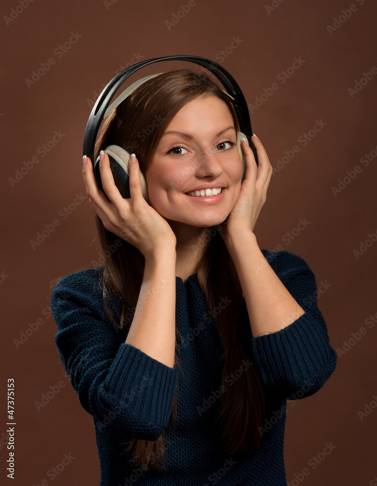 Smiling woman in headphones, dark brown background Smiling woman in headphones, dark brown background