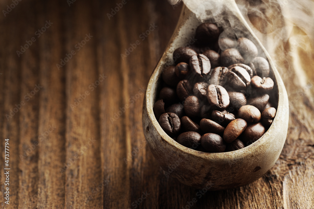 Fototapeta premium Close up of wooden spoon with coffee beans on it