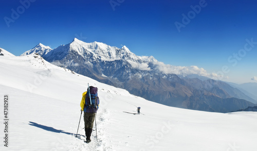 Lonely trekkers on big snow fieldsin Himalaya