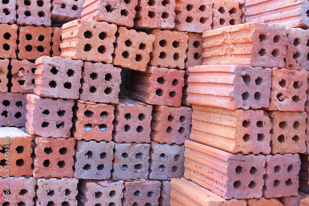 Orderly pile of construction red baked clay bricks