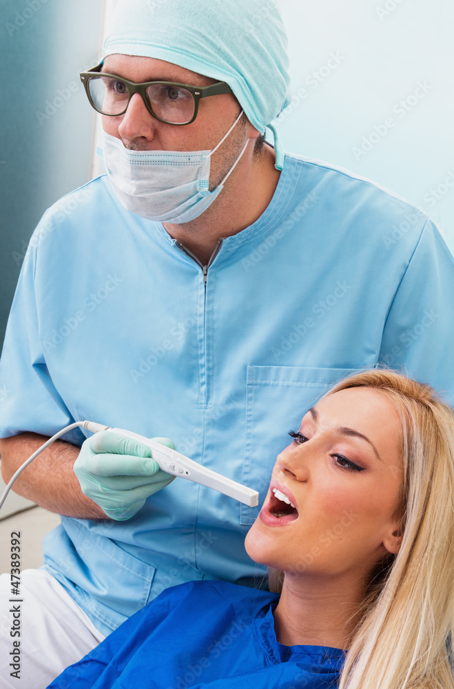 Dentist examines teeth of the patient with teeth-camera Dentist examines teeth of the patient with teeth-camera