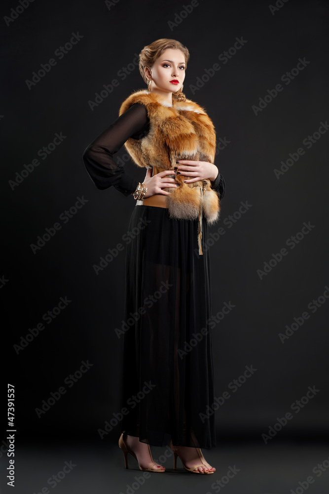 Fashion Model in Fur Collar and Black Dress Posing in Studio