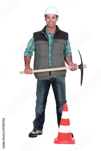 Man with pick-axe and traffic cone