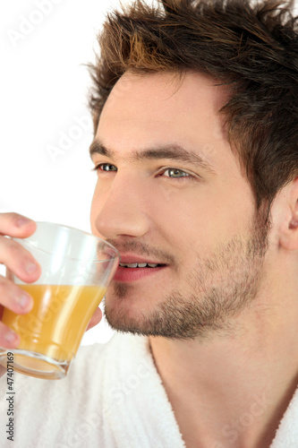 Man drinking a glass of orange juice