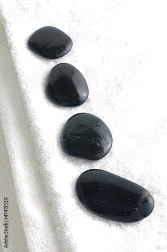 row of spa stone on white towel