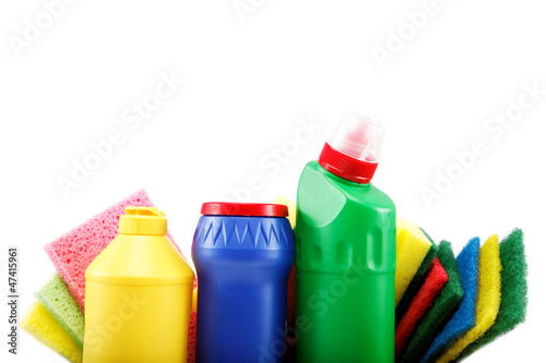 Detergent bottles, rubber gloves and cleaning sponge on a white