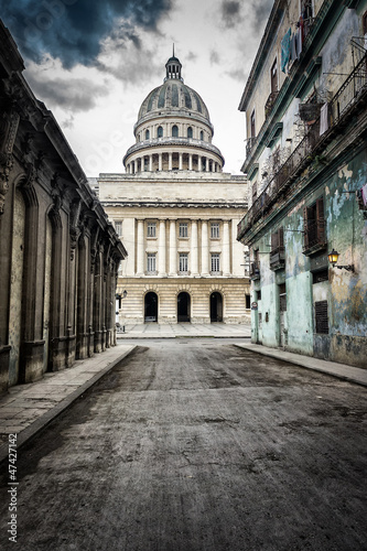 Foto Street with crumbling buildings leading to the Capitol in Havana