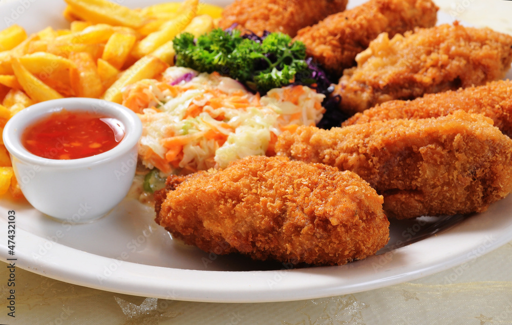 Fried chicken nuggets, French fries and vegetables Fried chicken nuggets, French fries and vegetables