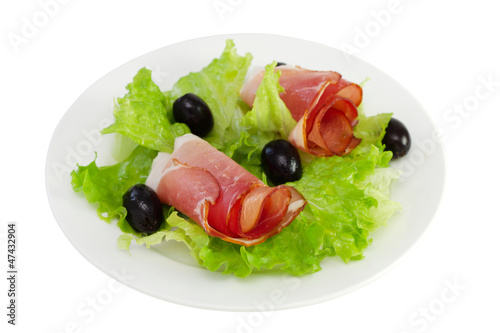 prosciutto with lettuce and olives on the plate