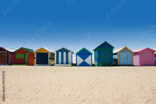 Bright and colorful houses on white sand beach