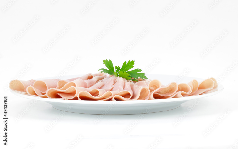 Ham sliced and arranged, served on a plate with parsley